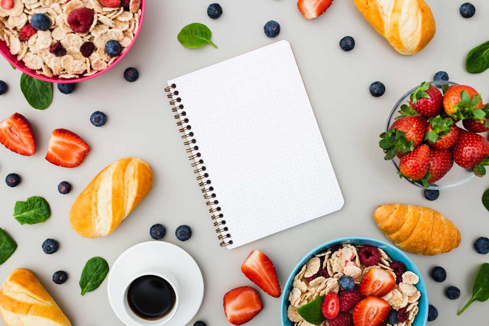 A diary surrounded by healthy foods.