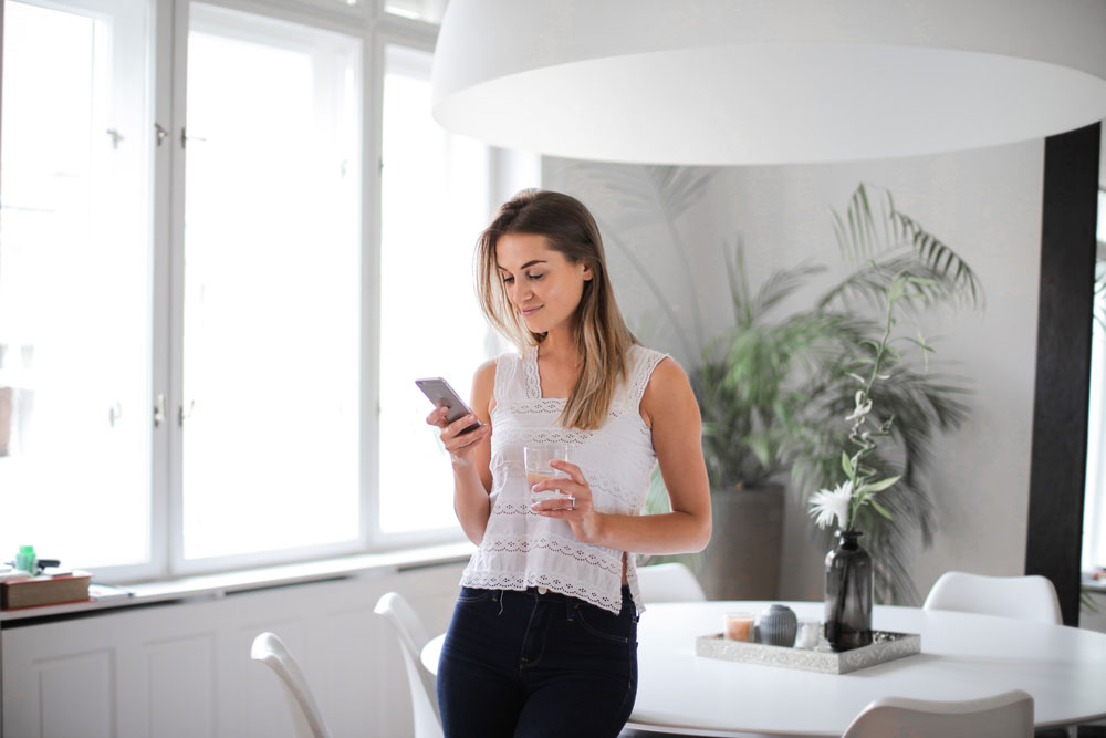 Gadis mengetik di aplikasi buku harian digital di rumah.