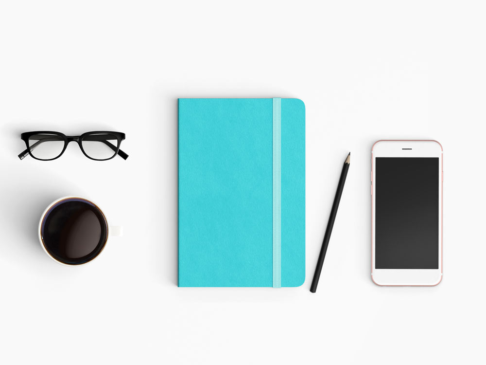 Modern workspace top view of a diary, phone and a cup of coffee.