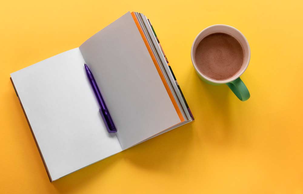 A journal book with pictures on a desk.