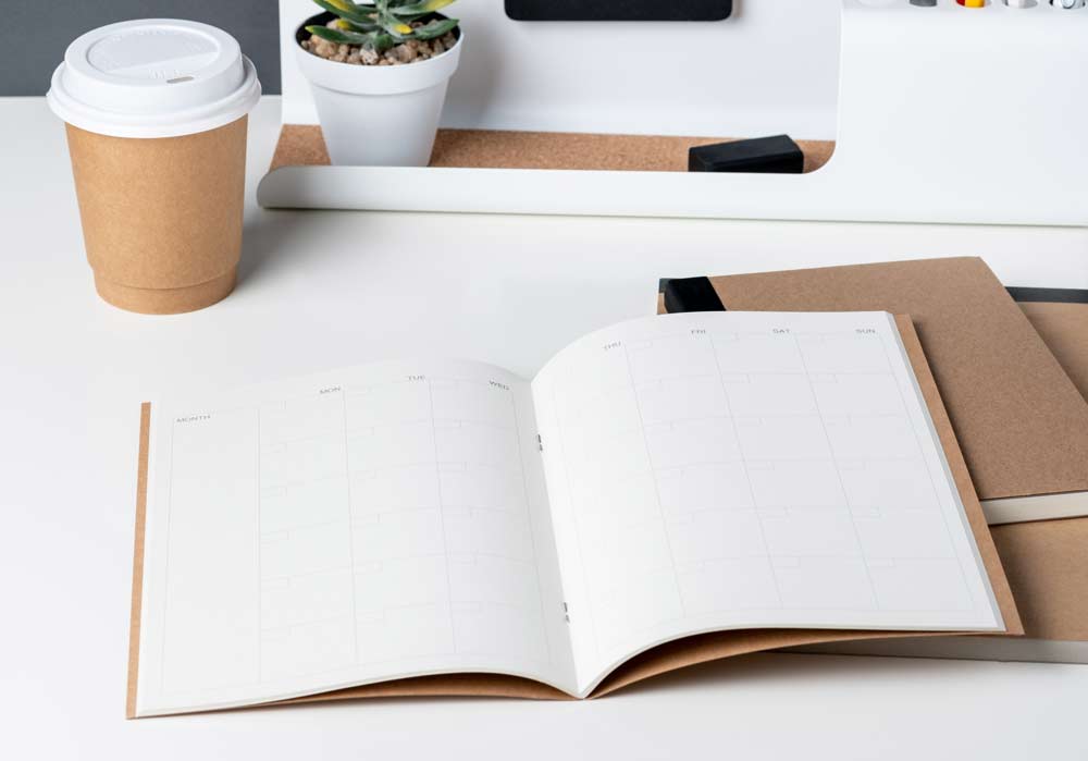 Top view of open calendar planner with modern office stationery.