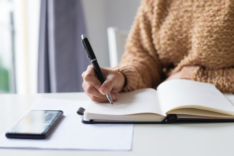 Gros plan sur une femme qui prend des notes.