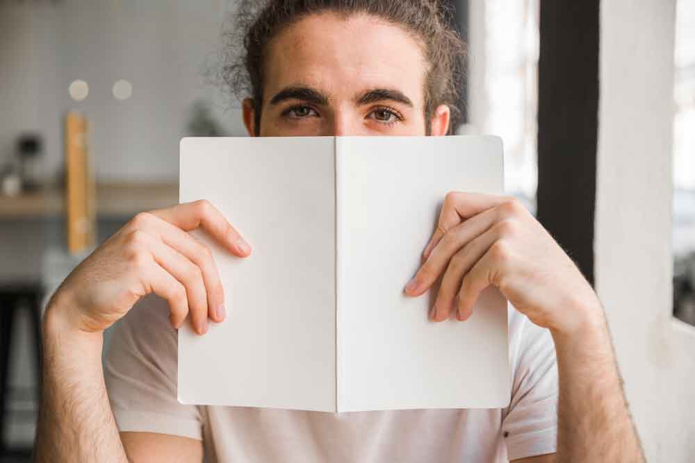 A handsome man holding a journal book.