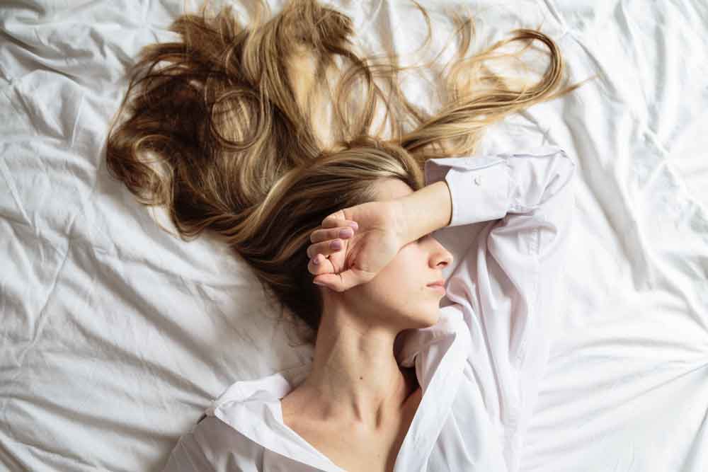 Portrait d'une belle femme blonde dormant et rêvant dans son lit.