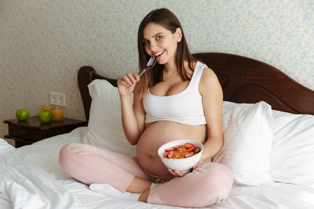 Portrait d'une jeune femme enceinte souriante.