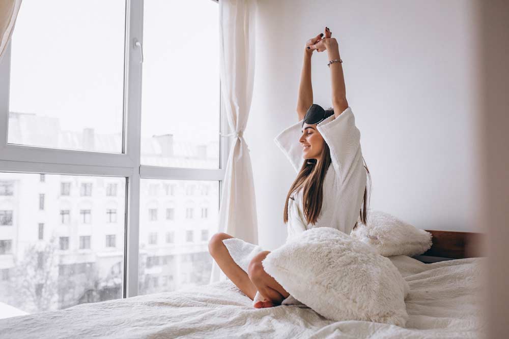 Una bellissima donna sul letto che si stiracchia al mattino.